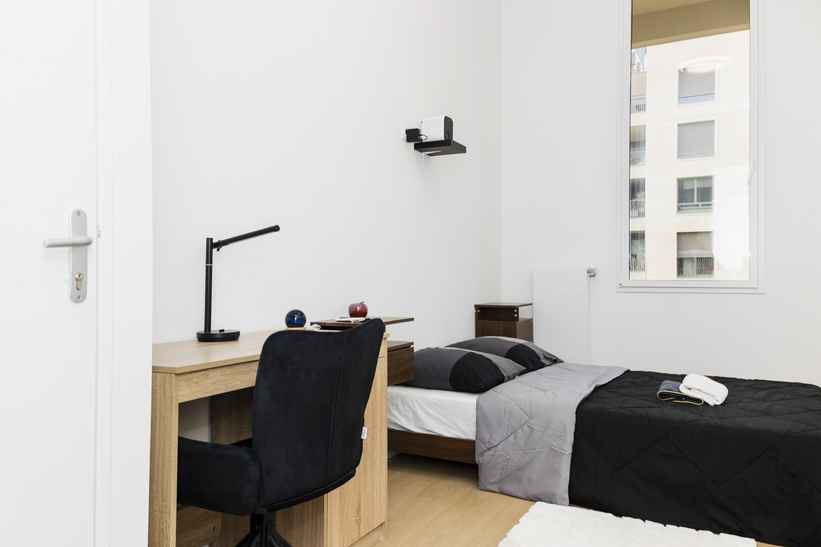 Furnished bedroom with bed, desk and window