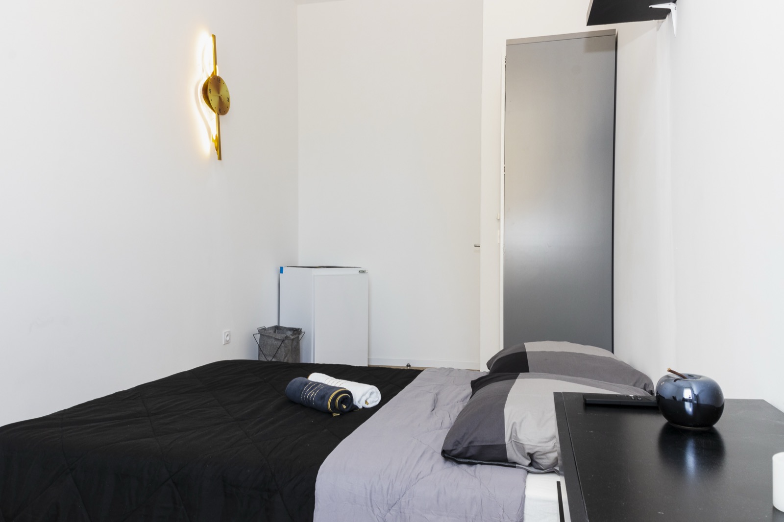 Chambre meublée avec lit et applique murale